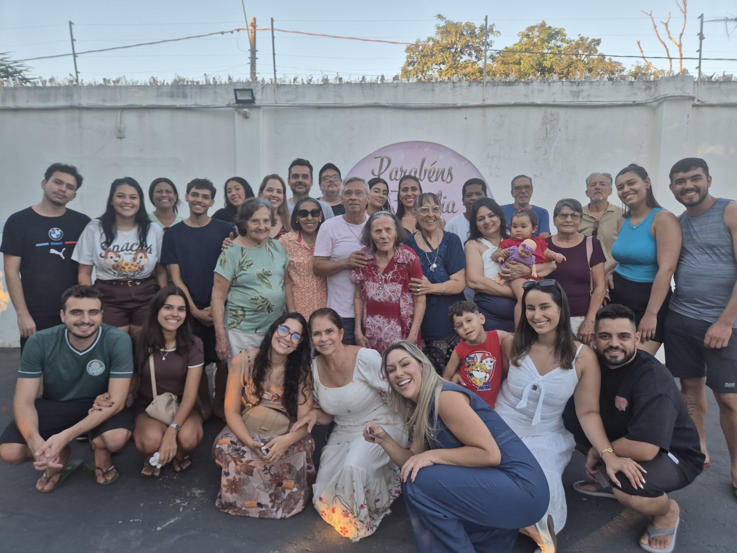 Famílias e equipe reunidas em frente à casa