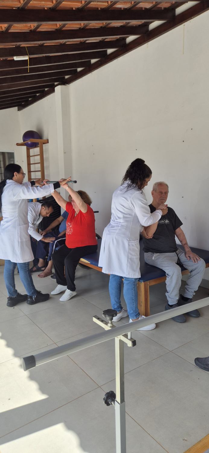 Fisioterapeuta acompanhando exercícios dos residentes no espaço de fisioterapia